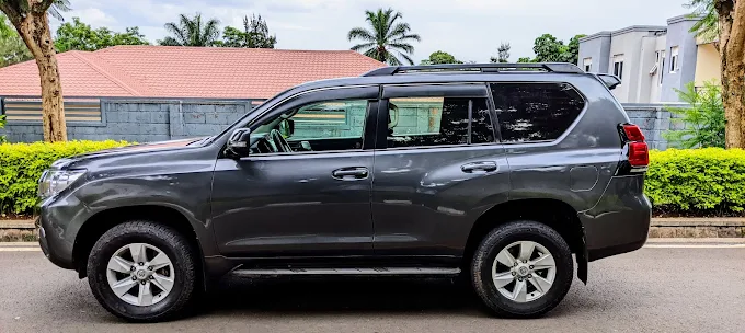 Toyota Land Cruiser Prado 4x4 driving on an asphalt road for Rwanda car hire safari transfers